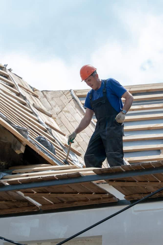 man repairing old wooden roof